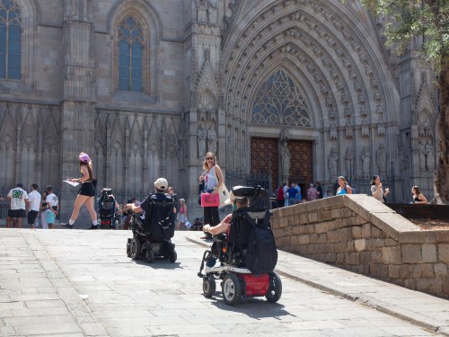 personas en silla de ruedas delante de la catedral