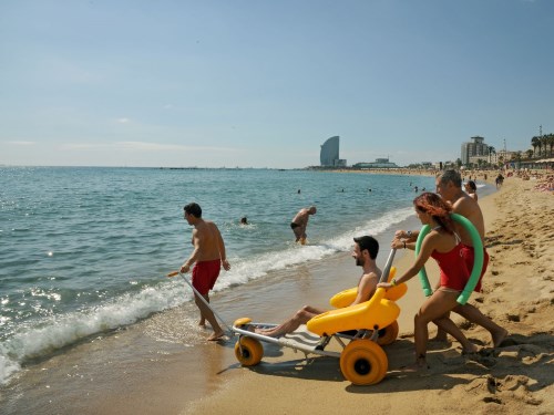 lifeguards helping a disabled person to reach the shore